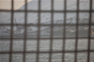 View of Dutch Harbor from the ship through a confining mesh barrier.